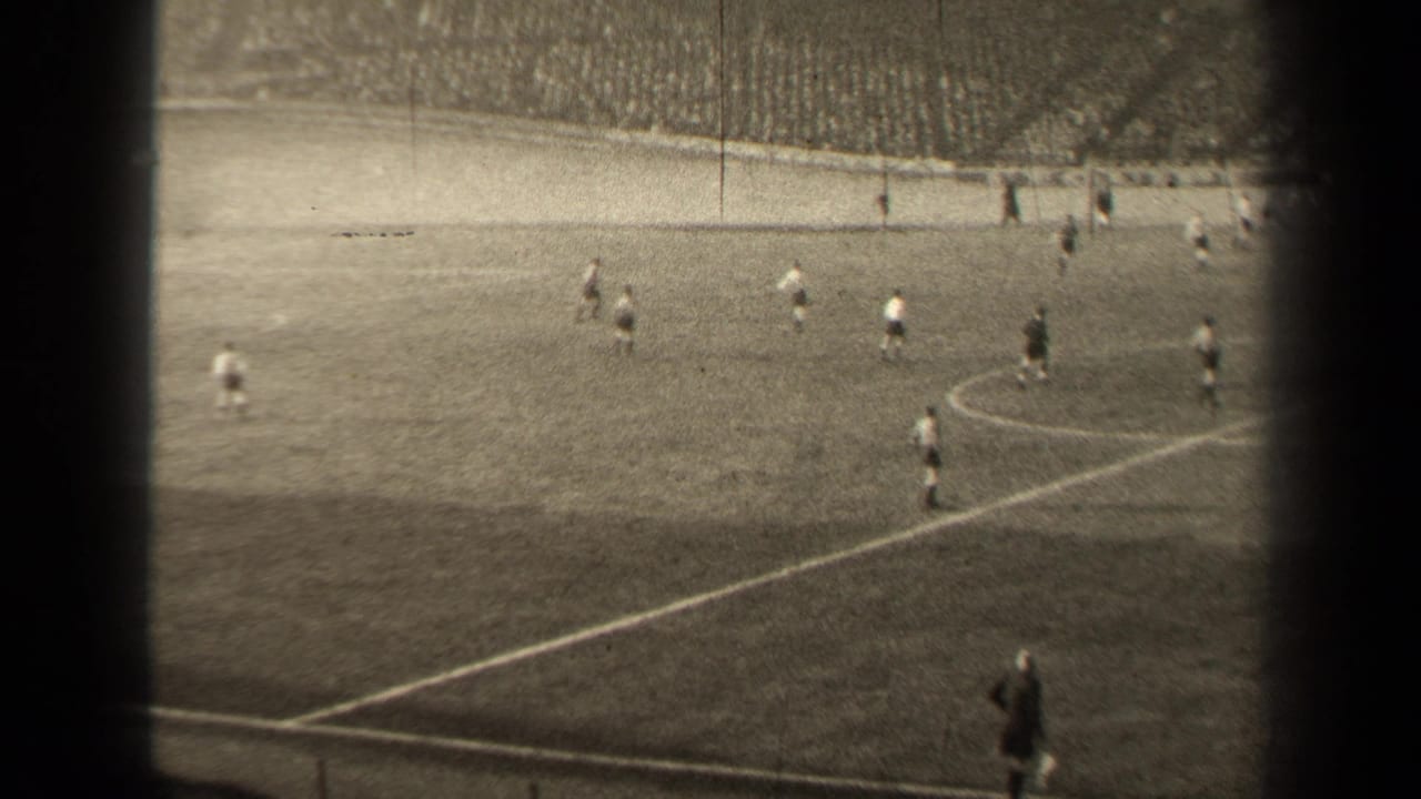1947 Paris soccer match seen from the stands, with players spread across the field and a large crowd in the background.