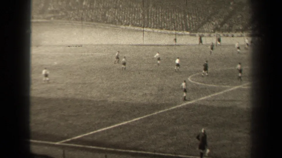 1947 Paris soccer match seen from the stands, with players spread across the field and a large crowd in the background.