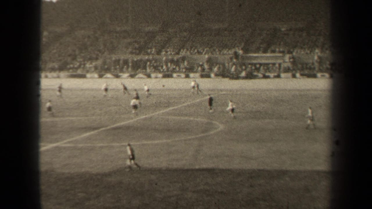 1947 Paris home-movie view of a soccer match, with players crossing a marked field before crowded stadium terraces.