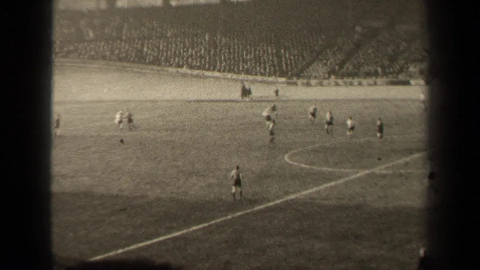 Wide 1947 Paris stadium shot showing a soccer match in progress, with players on the pitch and crowded terraces beyond.