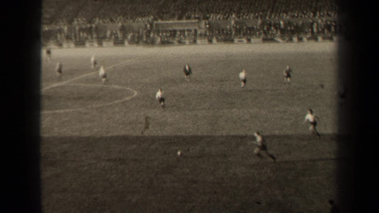 Soccer players are spaced across the field as one player runs near the ball on the right side.
