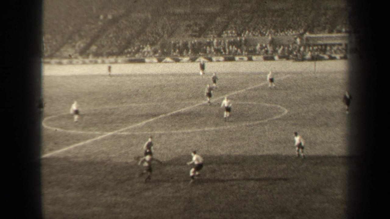 1947 Paris soccer match seen from the stands, with players moving near midfield and a crowd visible across the stadium.