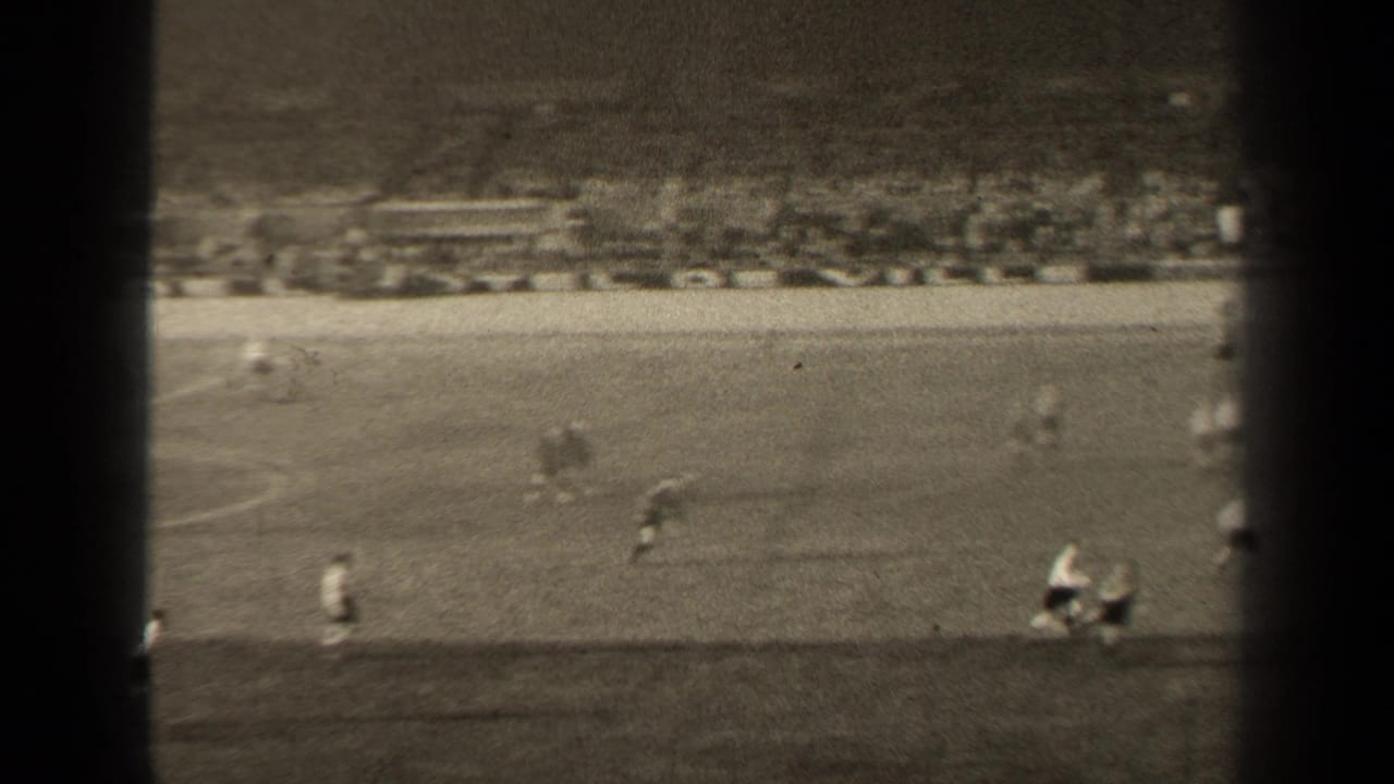 Wide 8mm view of the 1947 Paris match, showing players in motion on the pitch with blurred stadium seating in the background.