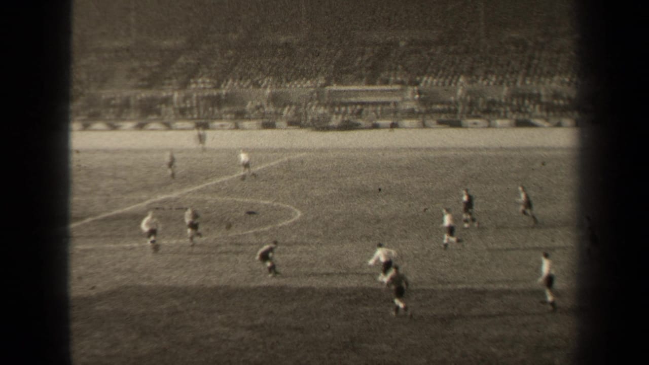 1947 Paris football match seen from the stands, with players moving near midfield and a large seated crowd beyond the pitch.