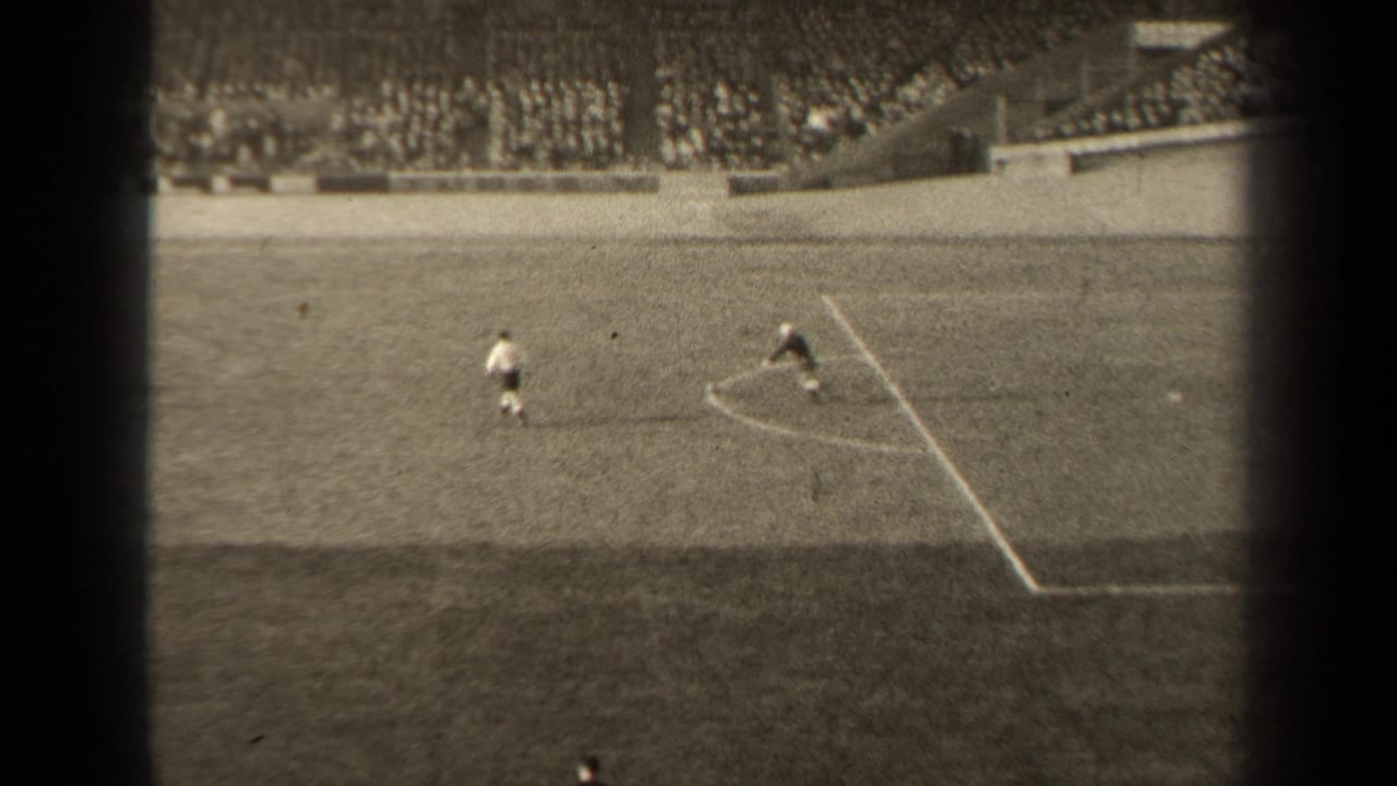 1947 Paris soccer footage from a high spectator view, showing players near field markings with packed stadium seating behind them.