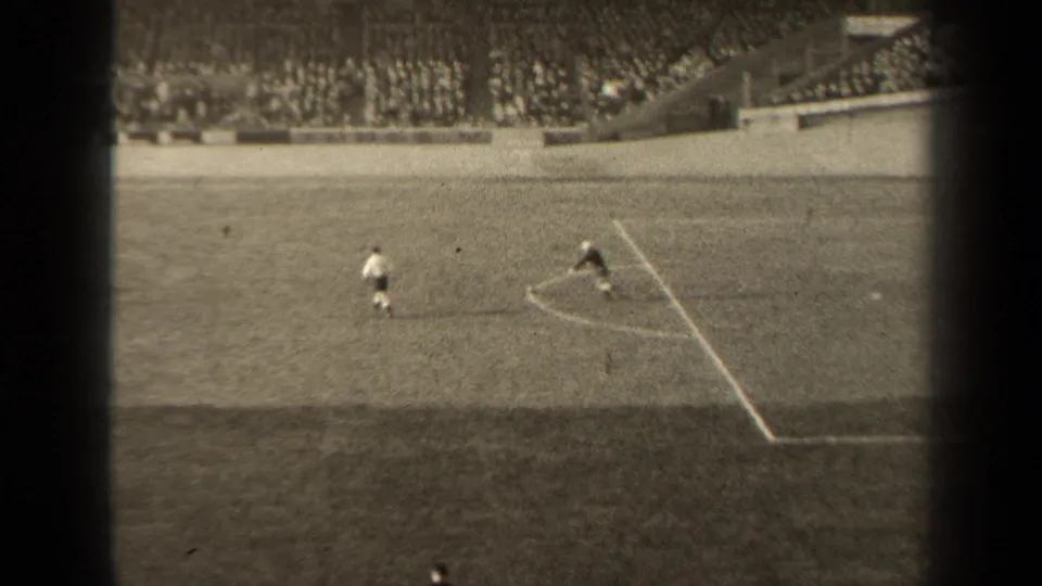 1947 Paris soccer footage from a high spectator view, showing players near field markings with packed stadium seating behind them.