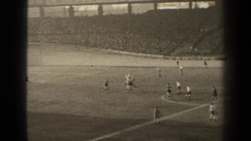 1947 Paris soccer match seen from above, with players spread near midfield and a packed stand behind the sideline.