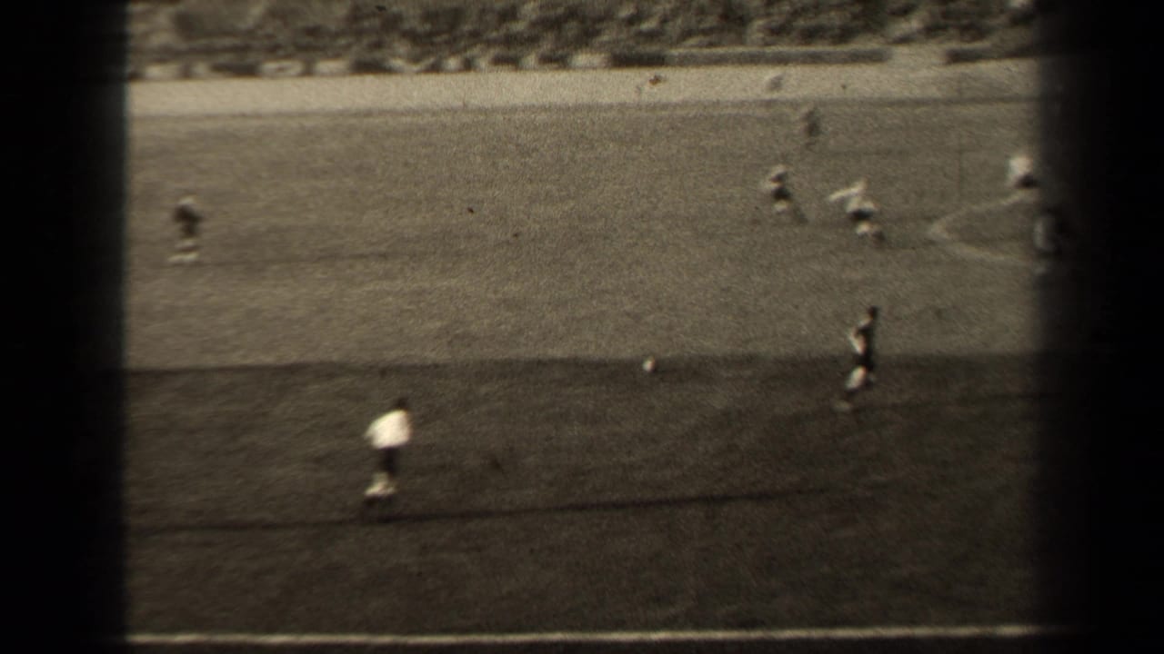 1947 Paris soccer footage shows players on a grass pitch, with dark film borders and stadium seating beyond.
