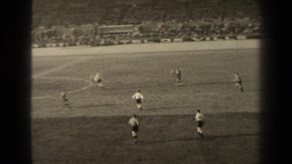 1947 Paris 8mm footage shows a wide stadium view of soccer players moving across a marked grass field.