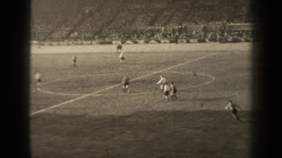 1947 Paris soccer match viewed from above, with players spread across the pitch and spectators filling the background stands.
