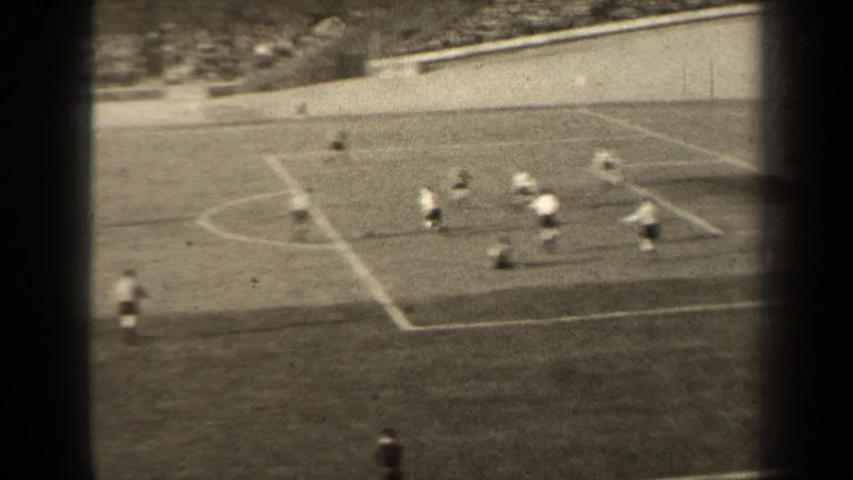 High-angle 1947 Paris stadium view of players converging inside the penalty area during a soccer attack.