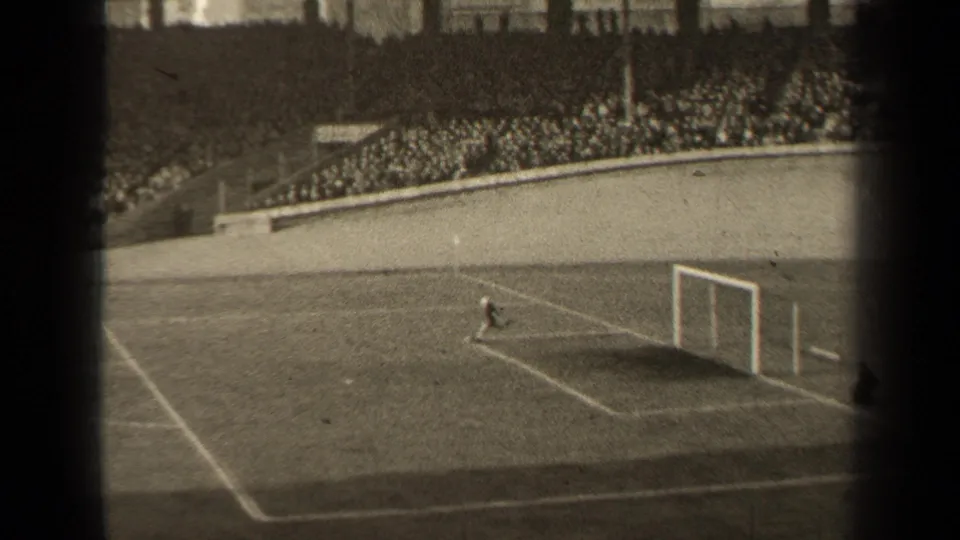1947 Paris 8mm frame with the goalkeeper near the goal area, broad field markings, and a dense crowd watching from the stands.