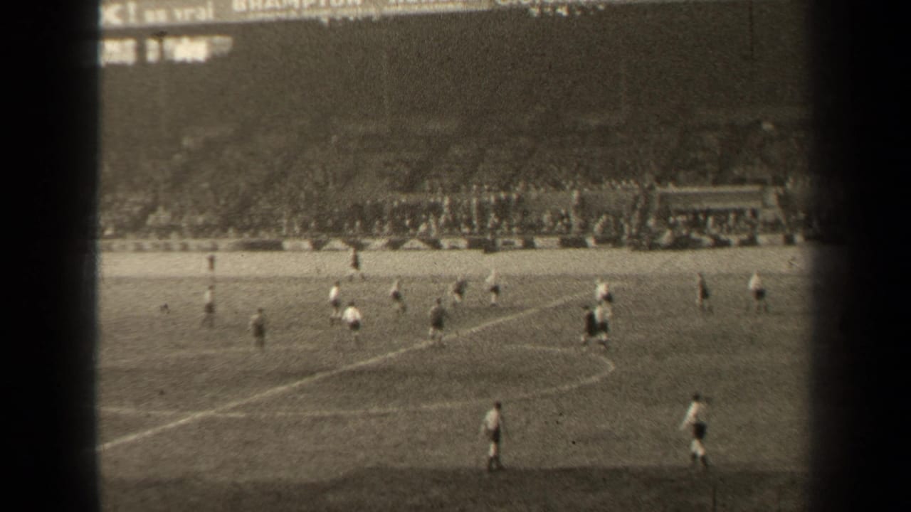 1947 Paris 8mm frame showing a football match from spectator distance, with players on the pitch and a packed stadium crowd beyond.