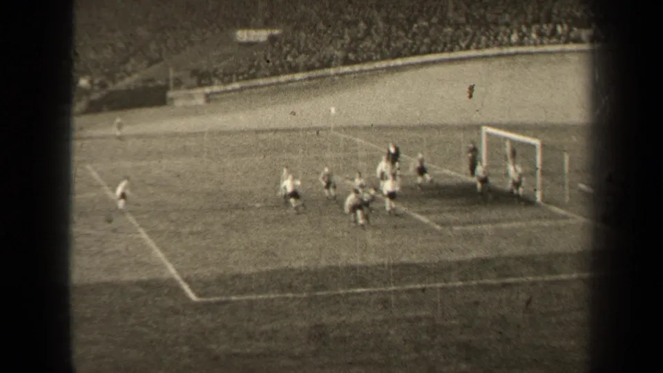 Black-and-white 8mm view of a 1947 Paris soccer match as players gather tightly near the goal line and penalty area.