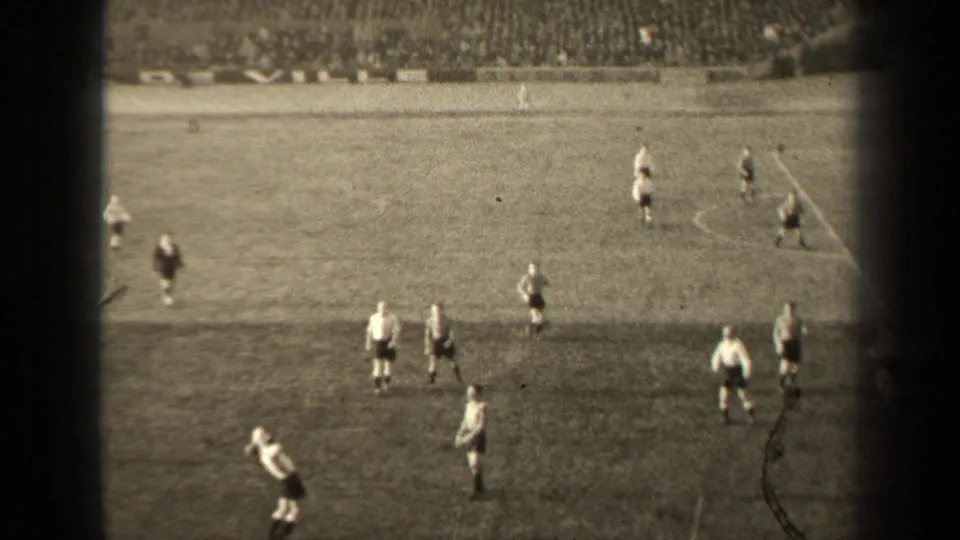 Spectator-shot 1947 Paris soccer footage showing players in light and dark uniforms positioned across the grass field.
