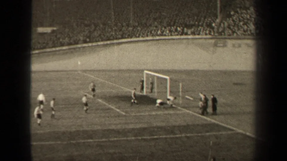 A goalmouth moment during the 1947 Paris football match, with players in light and dark kits moving around the box.