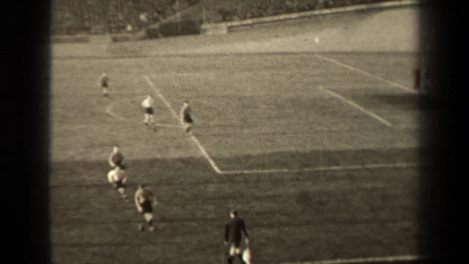 Wide 1947 Paris football view from the stands, showing players moving across the field toward the marked goal area.