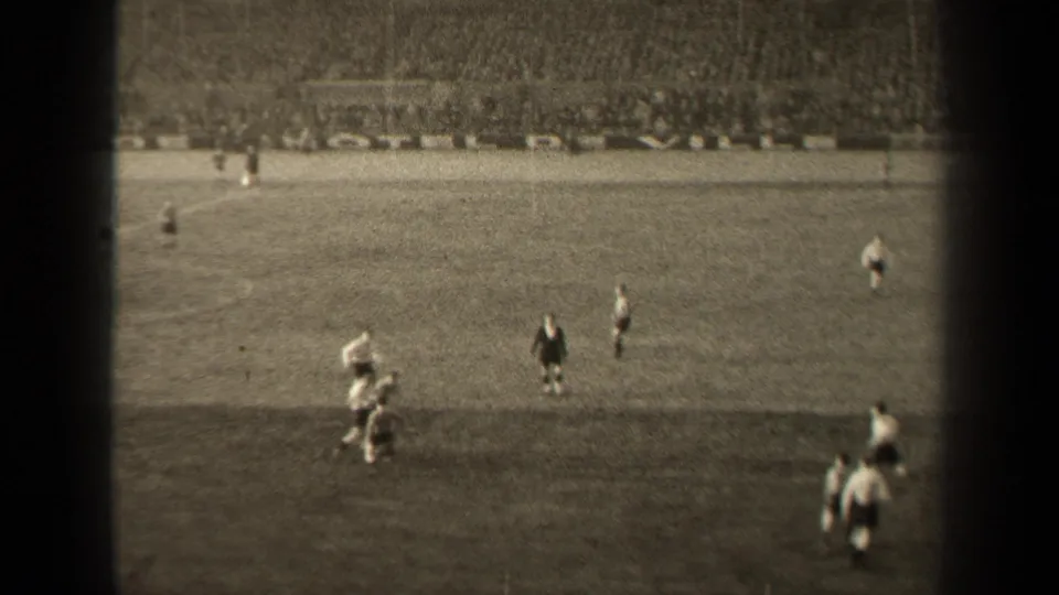 1947 Paris football match viewed from the stands, with players in light and dark kits moving across a grass field.