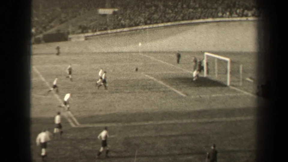 1947 Paris soccer action near the penalty area, with the goal, field markings, and crowded terraces visible in grainy 8mm footage.