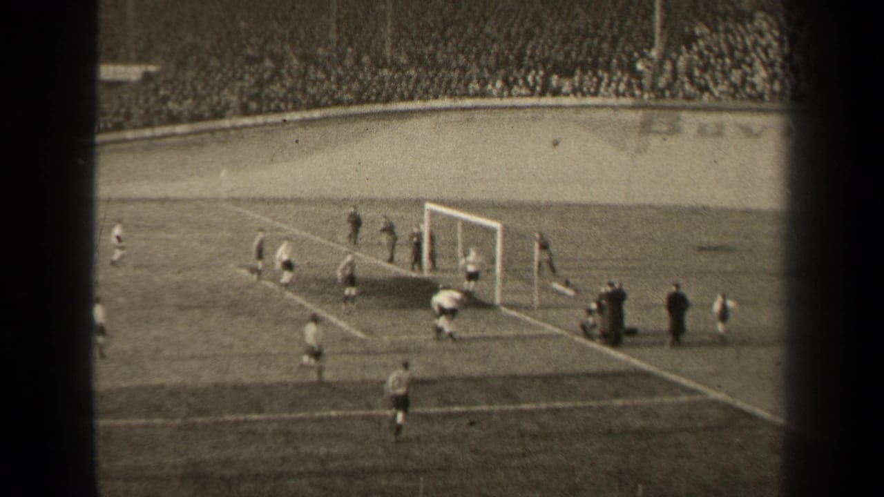 Football players gather near a goal in a crowded stadium, with 8mm frame borders visible.
