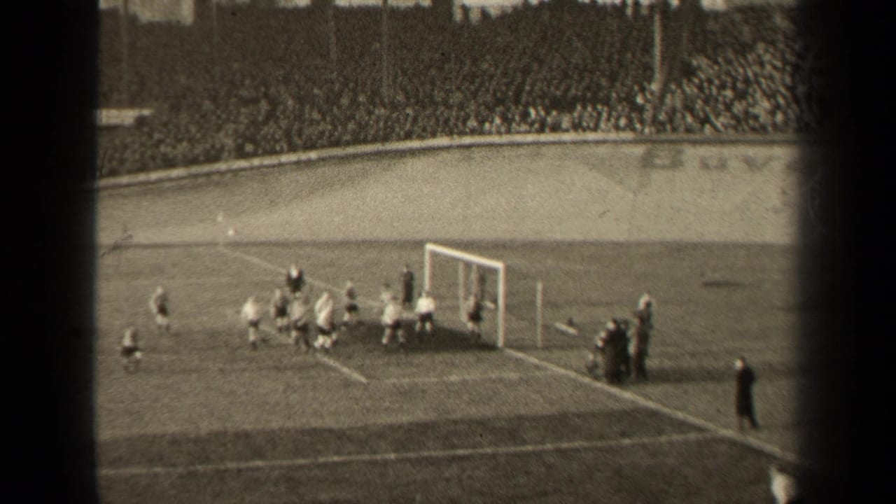 1947 Paris 8mm frame showing soccer players gathered near the goal, with sideline figures and crowded stands in the background.