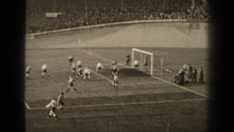 Black-and-white 8mm view of a 1947 Paris soccer match, with a player near the lower sideline and several players by the goal.