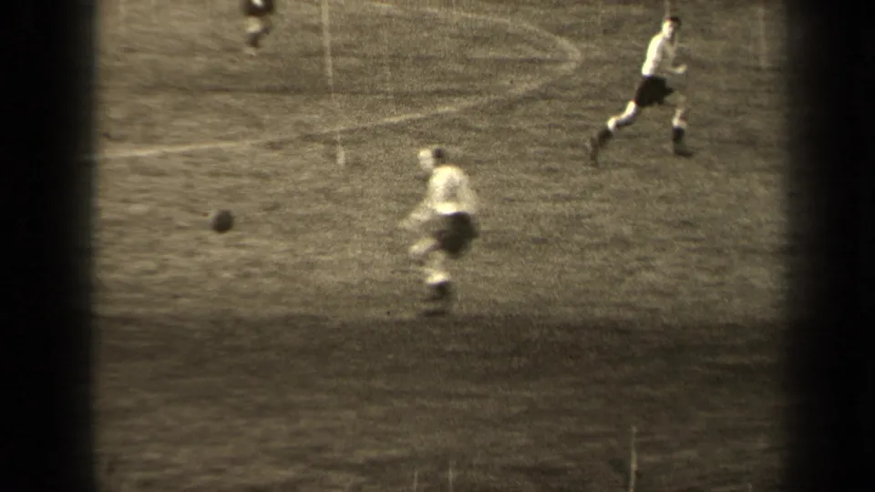 1947 Paris soccer action with one player near the ball and another running across the grass pitch.