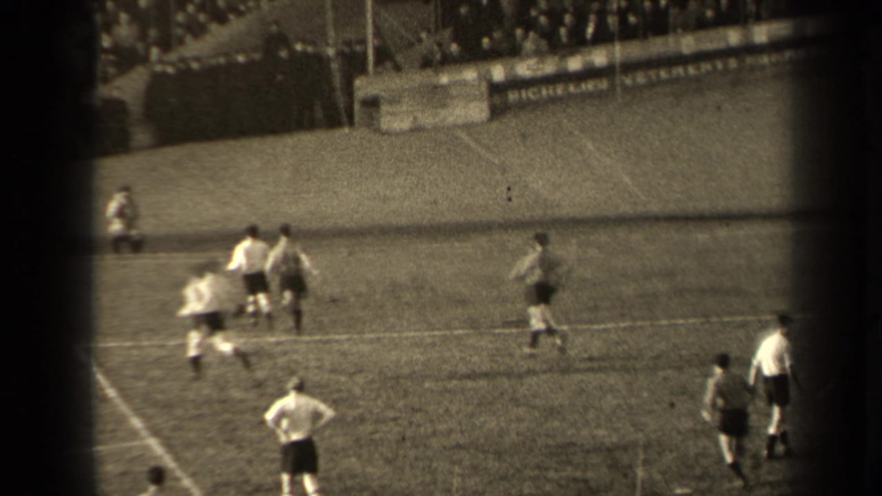 Paris 1947 soccer match seen from the stands, with players in light and dark shirts moving near midfield.