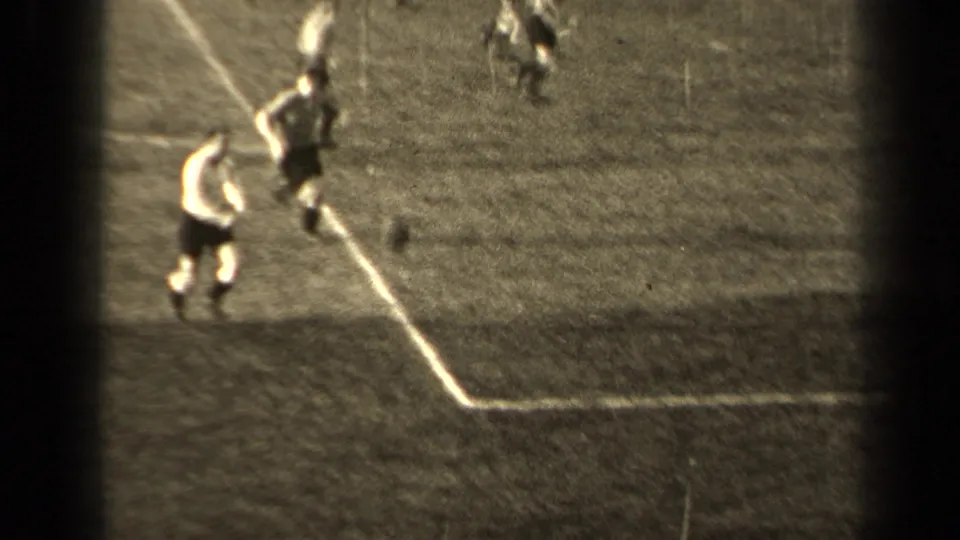 1947 Paris home-movie soccer frame showing a player moving along the marked edge of the pitch as the ball rolls nearby.