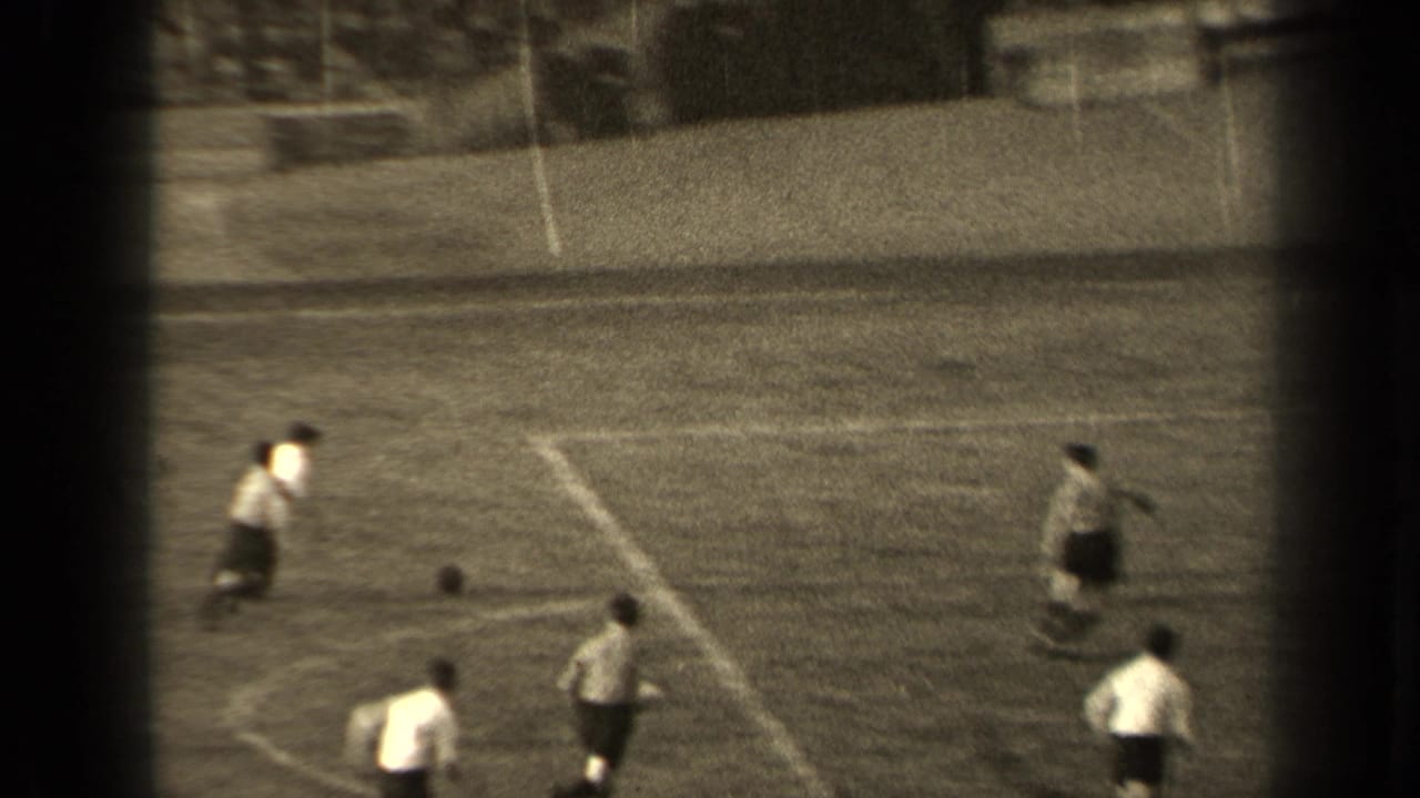 1947 Paris 8mm footage shows football players in light shirts and dark shorts moving across a field near the ball.
