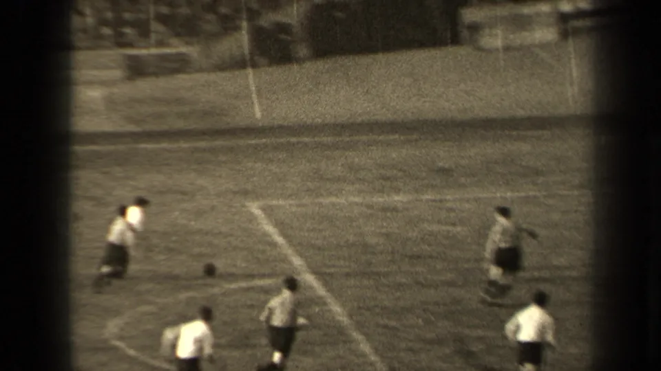 1947 Paris 8mm footage shows football players in light shirts and dark shorts moving across a field near the ball.