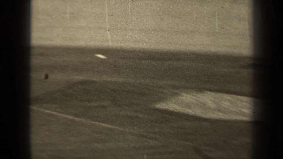The 1947 Paris home-movie frame shows an open section of the football field with boundary lines and the ball away from nearby players.