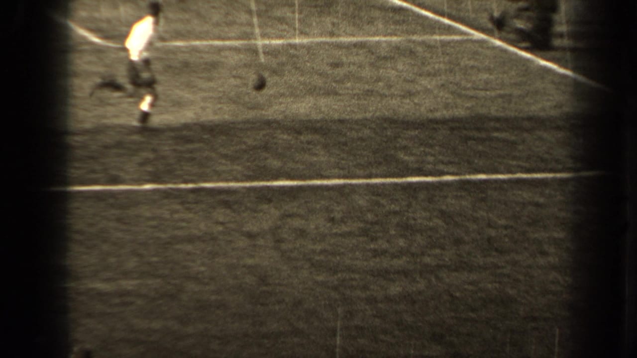 Player runs across the field toward a loose soccer ball.
