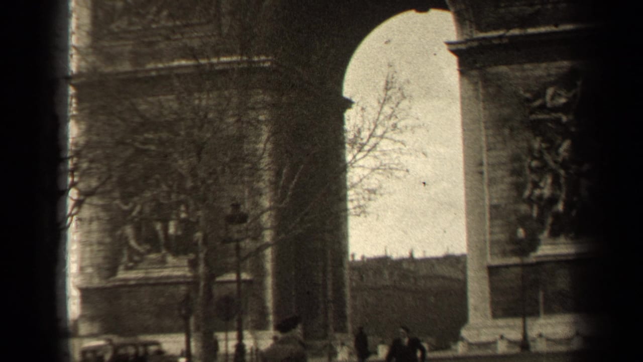 Central arch of the Arc de Triomphe with relief panels, bare trees, and distant people.