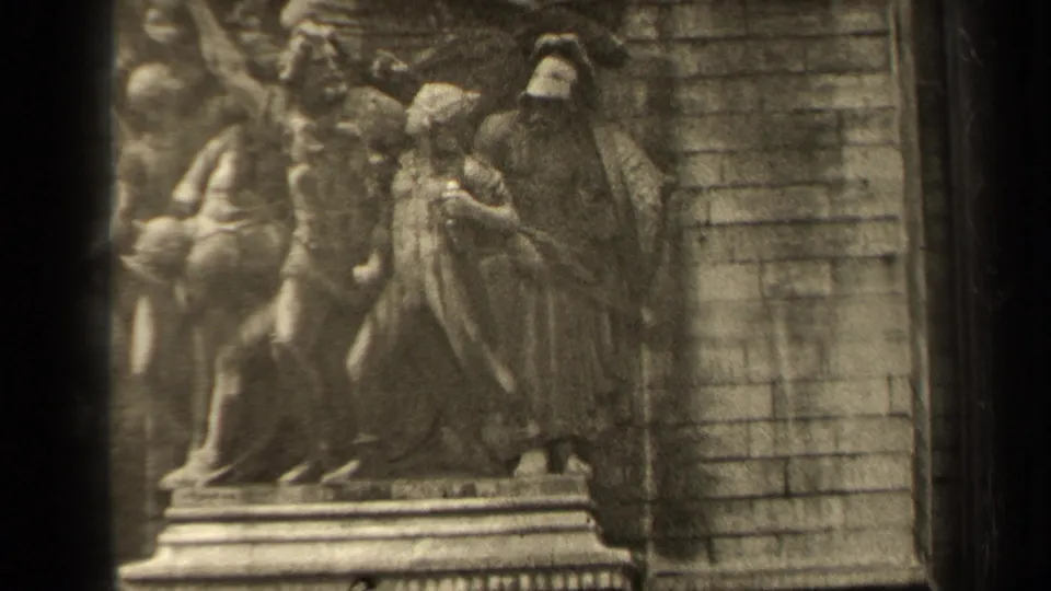Final 1947 Paris frame showing Arc de Triomphe relief sculpture, carved stone figures, and surrounding masonry within visible 8mm gate borders.