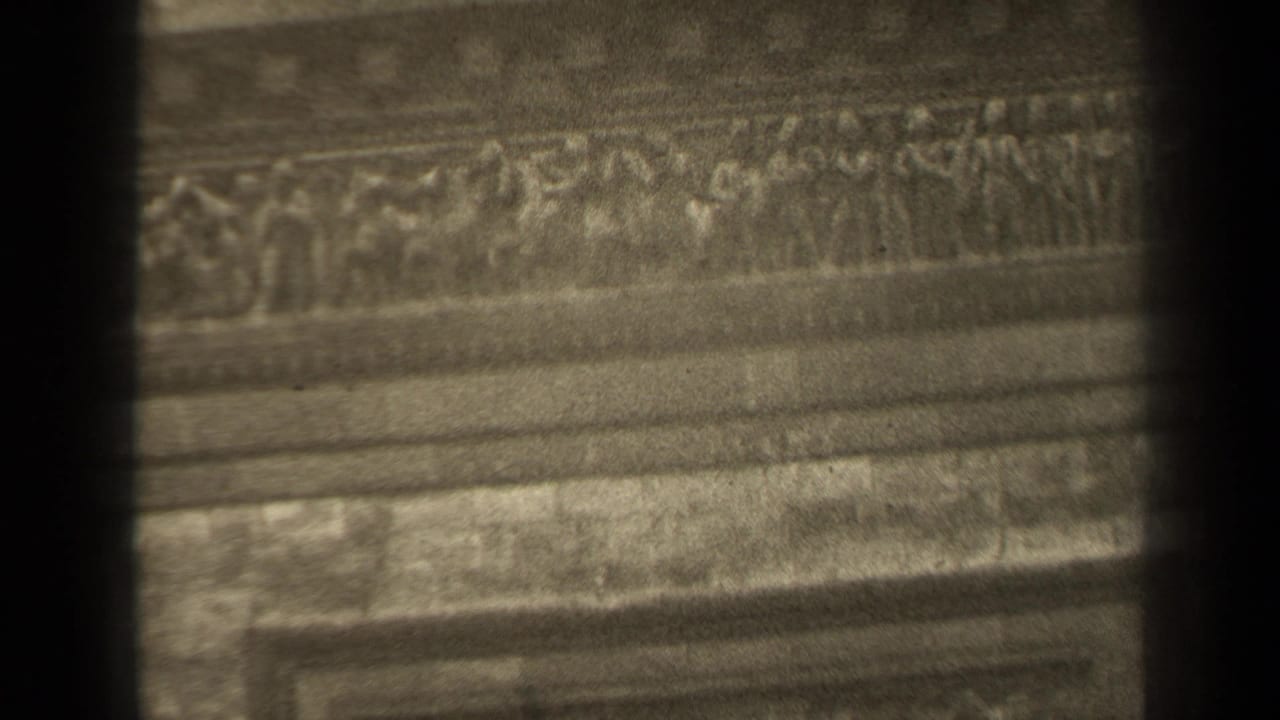 1947 Paris 8mm frame showing a close, soft-focused view of carved stone ornament and horizontal facade bands.