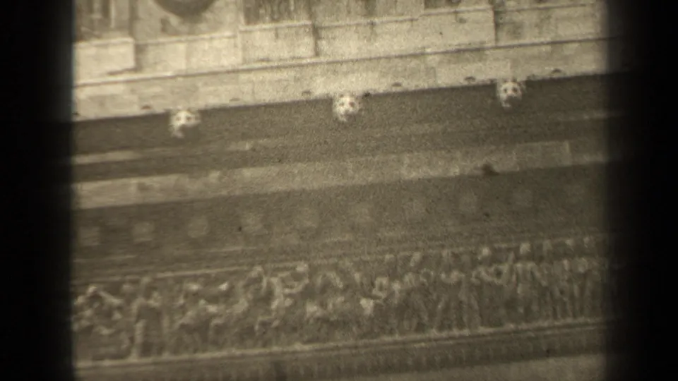 1947 Paris 8mm frame with relief carving, circular stone medallions, and layered facade trim visible through soft focus.