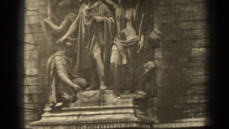 1947 Paris 8mm frame showing a classical stone sculptural group with robed figures set against masonry on a historic facade.