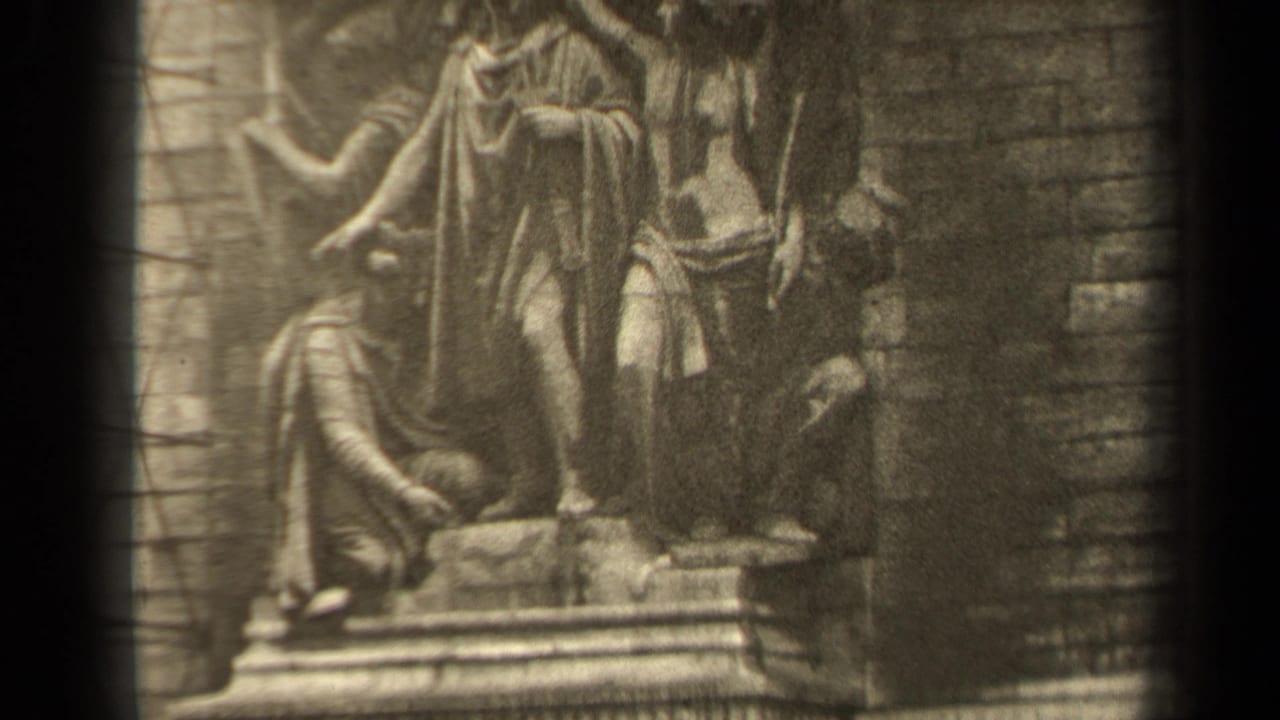1947 Paris 8mm frame showing a stone religious relief with robed figures, soft focus, and dark film-frame edges.