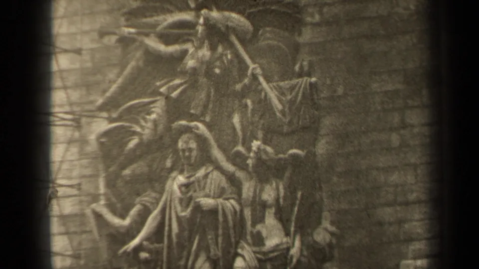 Final 1947 Paris frame holding on the relief's central robed figure, angel-like carving, and textured brick wall.