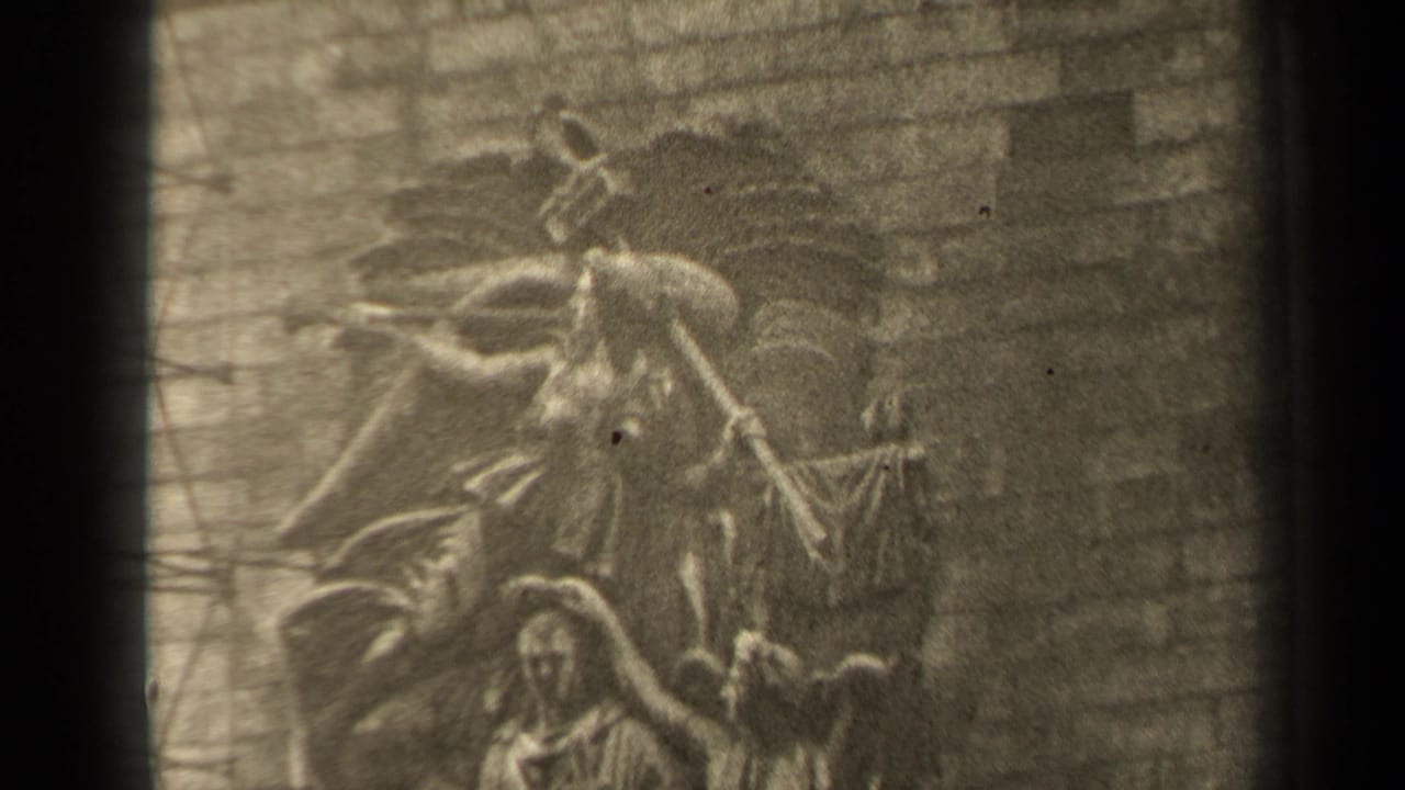 1947 Paris 8mm frame showing a soft-focus stone relief with human figures and surrounding masonry detail.