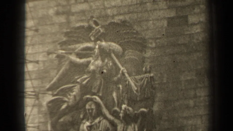 1947 Paris 8mm frame showing a soft-focus stone relief with human figures and surrounding masonry detail.