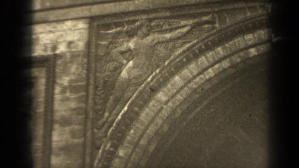 1947 Paris 8mm frame showing arched stone molding, carved relief figures, and decorative masonry in a close architectural view.
