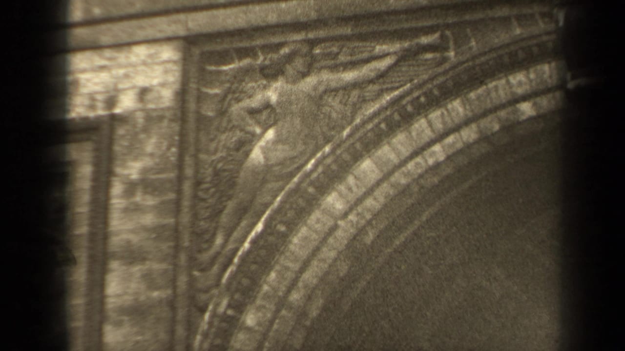 1947 Paris home-movie frame showing a winged carved relief and ornate arch detail in soft, grainy 8mm texture.