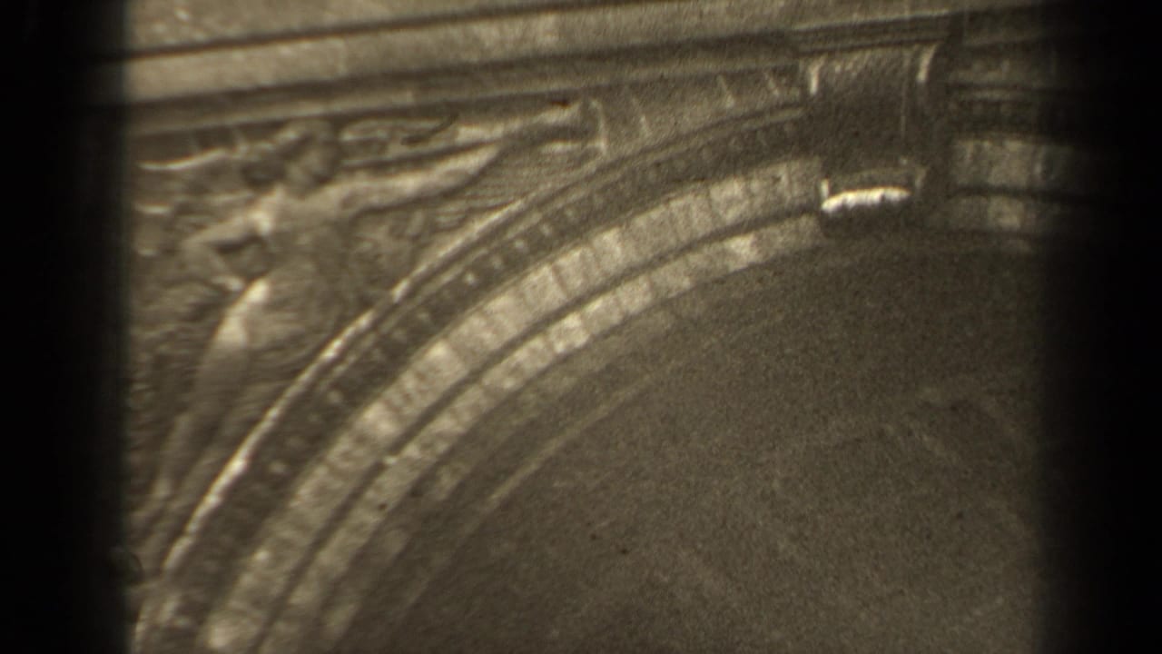 Carved relief and arch curve seen through dark 8mm frame borders.