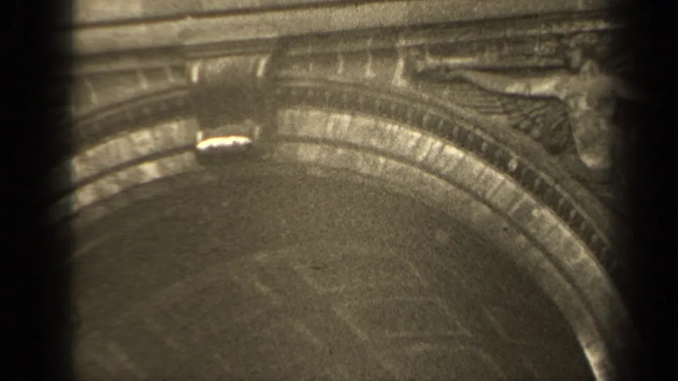 1947 Paris 8mm frame with an ornate arch, relief carving near the edge, and soft exposure variation across the stone surface.