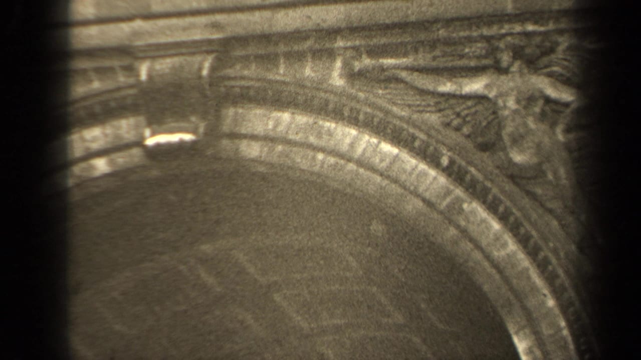 1947 Paris 8mm frame showing carved masonry above or beside an arched architectural feature at a memorial site.