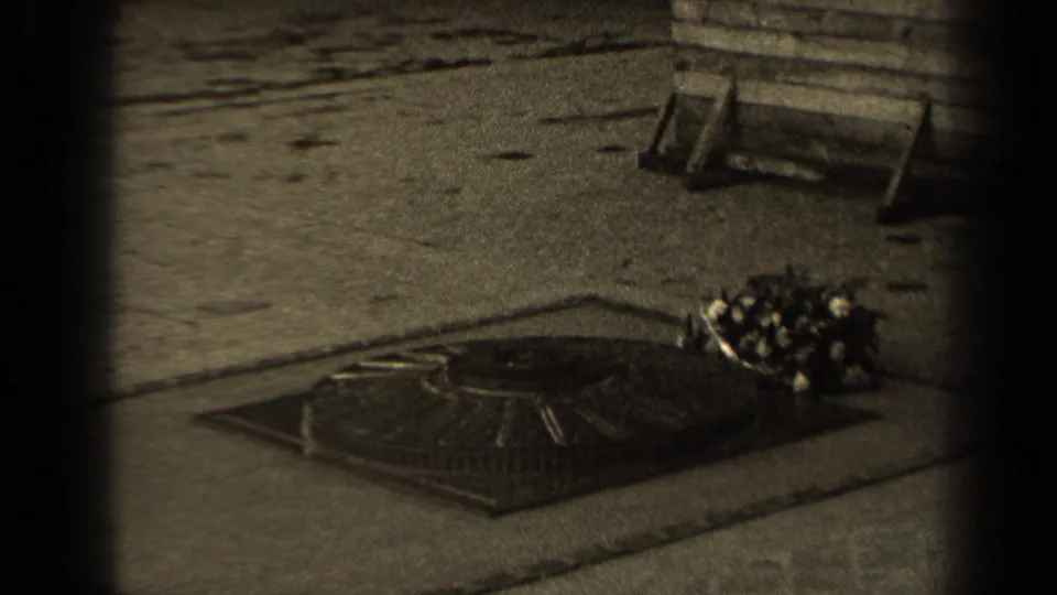 1947 Paris 8mm frame showing a low memorial flame or marker in stone paving with a bouquet placed to one side.