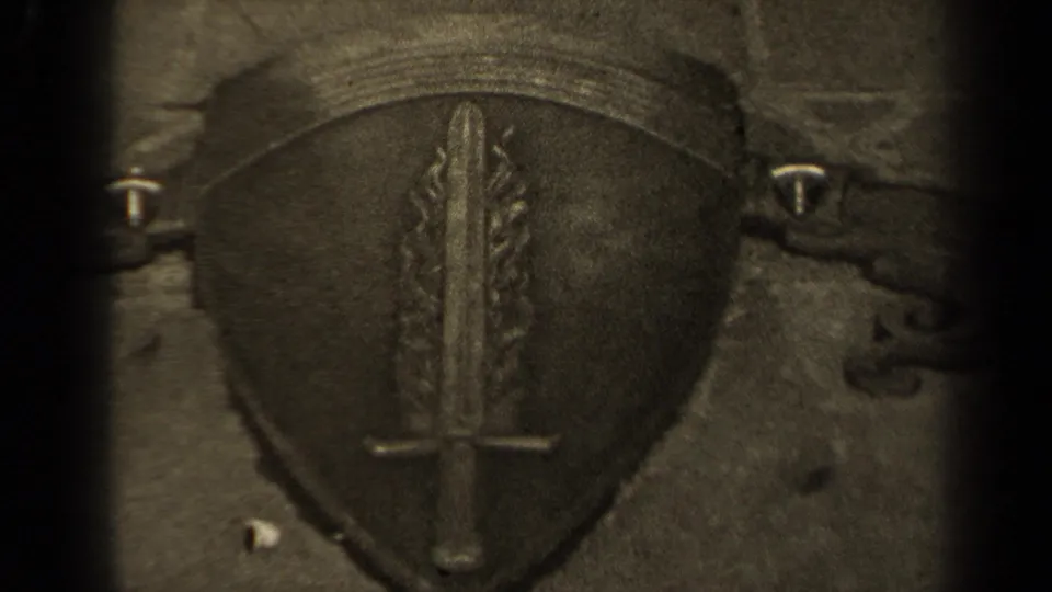 1947 Paris 8mm frame showing a carved stone shield with a central sword and flanking flame-like forms.