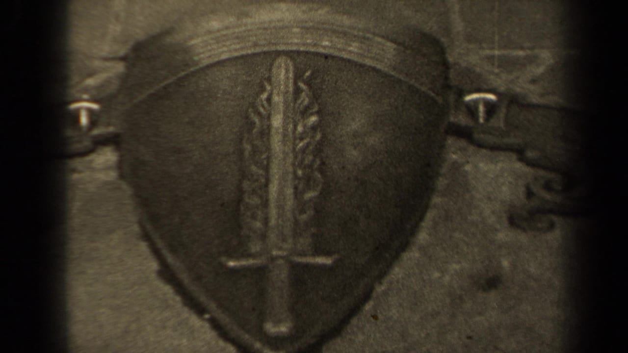 Stone shield emblem with sword detail framed between dark film edges.